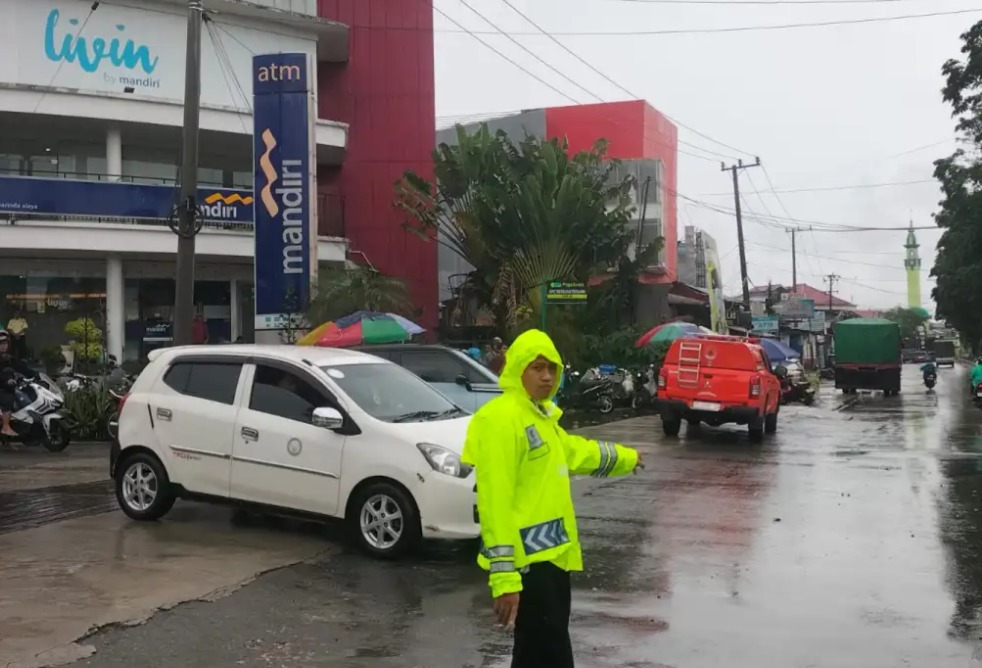 Personel Polsek Sungai Pinang dan Sat Lantas Polresta Samarinda Atur Lalu Lintas di Lokasi Banjir di Simpang Jalan D.I. Panjaitan dan Bukit Alaya